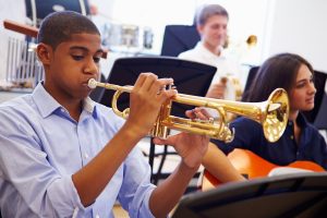 middle school boy plays a trumpet